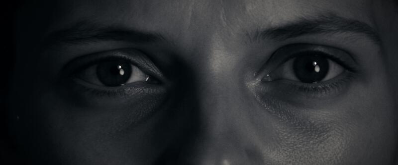 Extreme close-up of a woman's eyes in low contrast grey light.