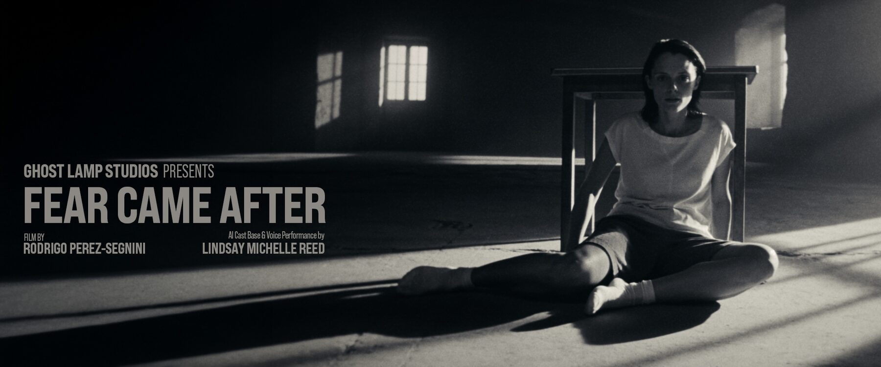 Poster frame: the woman sits on the floor beneath a wooden table in a shaft of light.